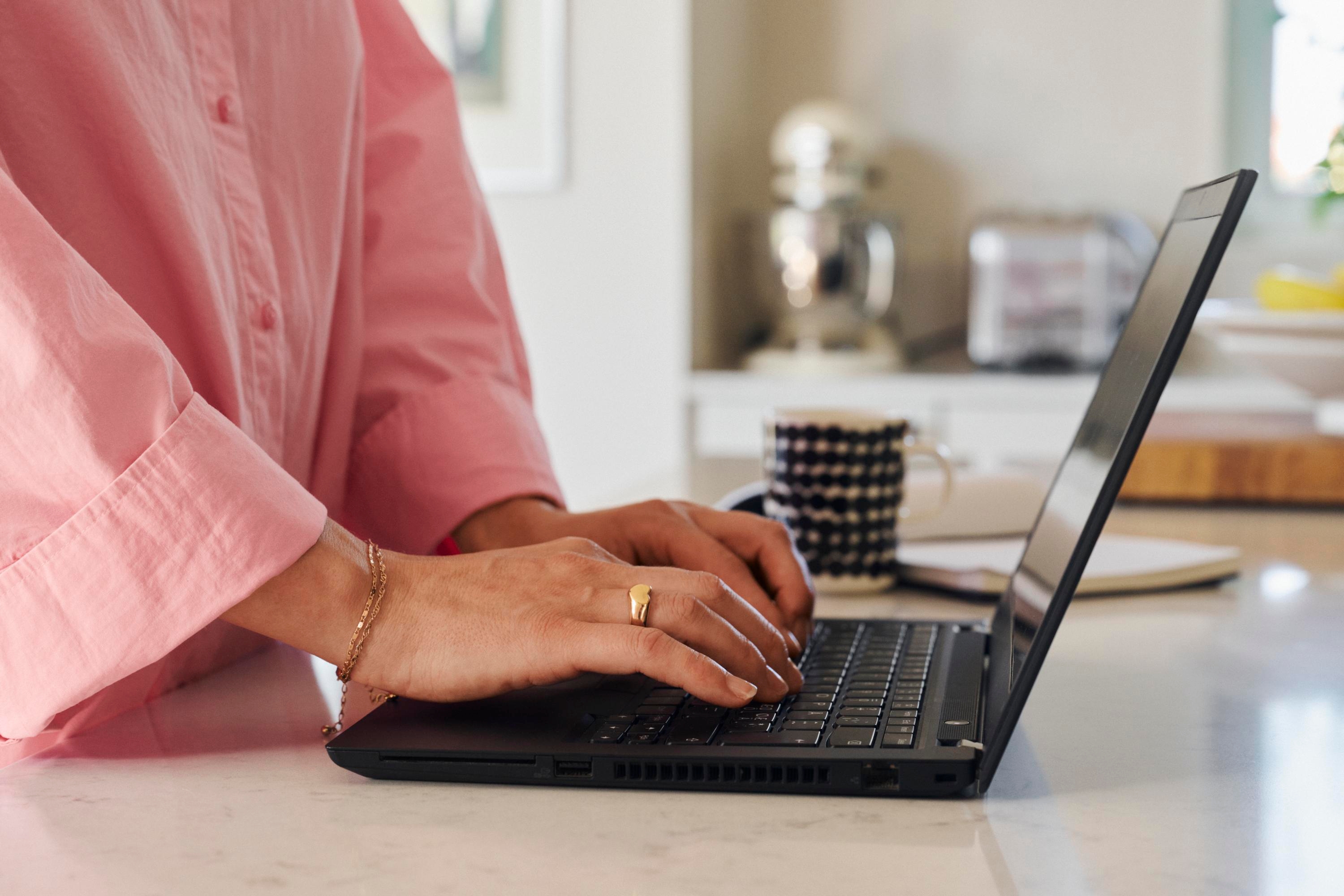 Närbild på en person som arbetar med en laptop